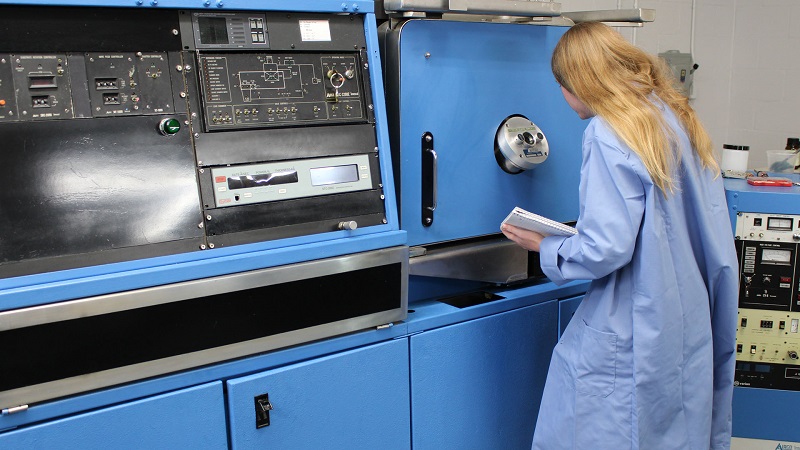 An image of a woman in a lab coat operating a machine. Testing and Environmental Services from Manasota Optics in Sarasota, FL.